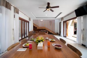 a dining room with a wooden table with food on it at Lamin Etan Saba Selatan in Keramas