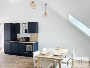 a dining room with a table and a kitchen at Le Cosy - 50m de la plage in Bray-Dunes