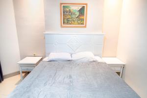 1 dormitorio con 1 cama azul y 2 mesas en Hotel Permata Malioboro, en Yogyakarta