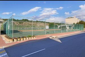 a tennis court with a fence on a tennis court at Breezy Sunny Apartment in Cape Town
