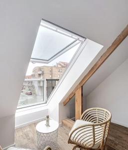 a living room with a large window and a chair at Le Cosy - 50m de la plage in Bray-Dunes