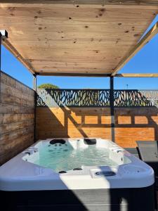 Un jacuzzi en una terraza con techo de madera. en Gîte & Spa Le Villemachois - 4 étoiles - Jacuzzi couvert - Calme et Indépendant - Clim - Parking - 5 min Carcassonne, en Villemoustaussou 16 fotos más