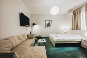 un soggiorno con un divano e un letto di Athenian Suite by Zeussuites ad Atene