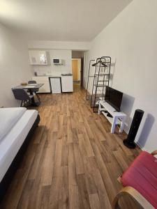 a room with a bed and a desk and a kitchen at Apartments EFDE Boardinghouse Heilbronn in Heilbronn