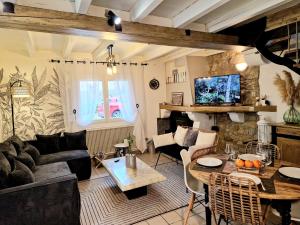 a living room with a couch and a table at Maison Richelieu in Bram