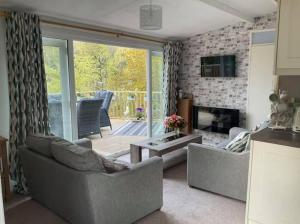 a living room with two couches and a fireplace at MOEL SIABOD - GLAN GWNA HOLIDAY PARK in Caernarfon