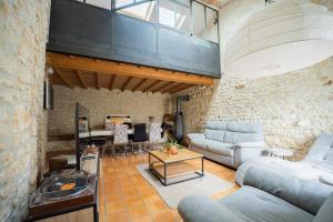 a living room with a couch and a table at Havre de paix en Charente Maritime avec 3 formules d hébergement sur mesure de 1 à 14 voyageurs in Gémozac