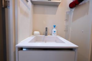 Un lavabo de baño con una botella de jabón encima en YIYou Japan秋葉原302, en Tokio 20 fotos más