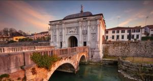 a bridge over a river with a building at AGRITURISMO Barone Rosso in Treviso