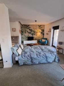 a bedroom with a large bed and a couch at Chez Steph et Guillaume in Châtenois