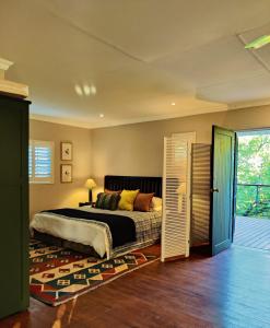 a bedroom with a bed and a sliding glass door at The Loft in Kiepersol