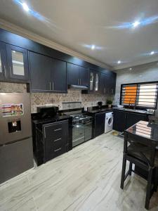 a large kitchen with black cabinets and a table at Résidence Daniel in Pointe-Noire
