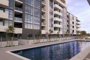 贝尔康嫩Modern 1 Bedroom apartment with Pool, Gym & Water Views的一座带游泳池的公寓大楼的图片