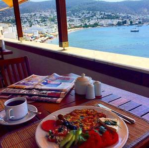 a table with a plate of food and a cup of coffee at Bac Pansiyon in Bodrum City