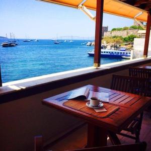 a wooden table with a cup of coffee on top at Bac Pansiyon in Bodrum City