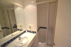 een witte badkamer met een wastafel en een douche bij Bac Pansiyon in Bodrum City