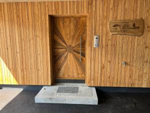 eine Holztür auf einem Holzgebäude mit einem Schild darauf in der Unterkunft Wildkogel-Villa in Bramberg am Wildkogel