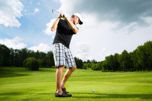 a man swinging a golf club on a golf course at Ferienwohnung in Bad Saarow in Bad Saarow