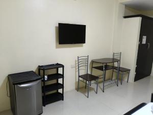 ein Zimmer mit zwei Tischen, zwei Stühlen und einem Flachbildfernseher in der Unterkunft Hidaway Resort in Pundaquit