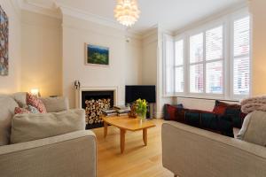 a living room with two couches and a fireplace at Veeve - Stylish Stapleton in London