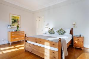 a bedroom with a wooden bed and a dresser at Veeve - Stylish Stapleton in London