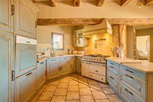 cocina grande con electrodomésticos blancos y armarios azules en Villa du Monde - 160 m² avec piscine privée, en Saint-Rémy