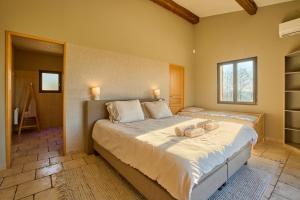 Un dormitorio con una cama grande con toallas. en Villa du Monde - 160 m² avec piscine privée, en Saint-Rémy 12 fotos más