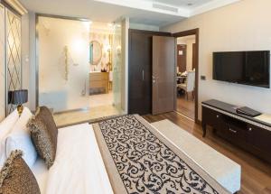 a bedroom with a bed and a television and a living room at Grand Makel Hotel Topkapi in Istanbul