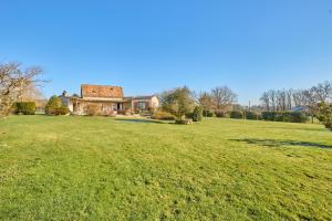 un gran campo de césped con una casa en el fondo en Villa du Monde - 160 m² avec piscine privée, en Saint-Rémy