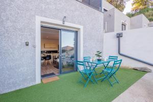 a patio with chairs and a table with a chalkboard at La Casa Di Castagni - Climatisé avec terrasse in Oletta
