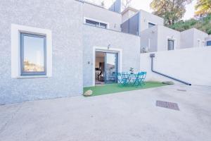 a white house with a patio with blue chairs at La Casa Di Castagni - Climatisé avec terrasse in Oletta +7 photos