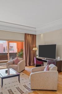 un soggiorno con due divani e una TV a schermo piatto di Kenzi Menara Palace & Resort a Marrakech