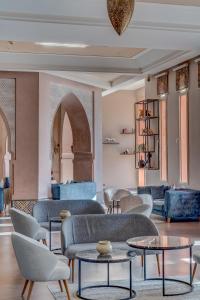 un soggiorno con divani, tavoli e sedie di Kenzi Menara Palace & Resort a Marrakech