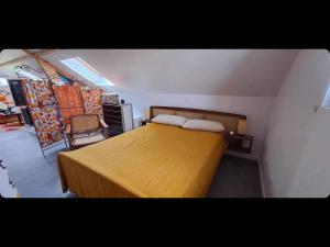 una camera da letto con un letto con un copriletto giallo di Le Vin-Tage a Broin