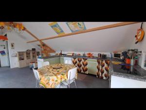 a kitchen with a table and chairs in a room at Le Vin-Tage in Broin
