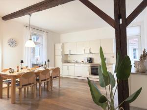 una cucina e una sala da pranzo con tavolo e sedie di Luxury Old Town Suite - XXL Terrasse & XXL Penthouse a Heidelberg Altre 38 foto