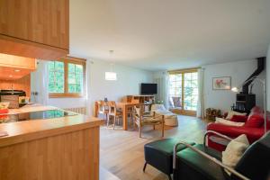 Una cocina y una sala de estar con mesa y sillas. en Chalet Luise 3, en Wengen