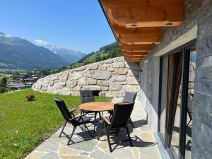 einen Tisch und Stühle auf einer Terrasse mit Aussicht in der Unterkunft Wildkogel-Villa in Bramberg am Wildkogel