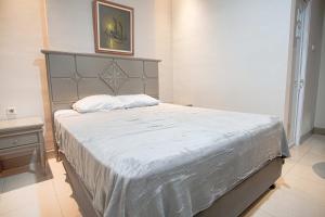 una camera con un grande letto con testiera grigia di Hotel Permata Malioboro a Yogyakarta