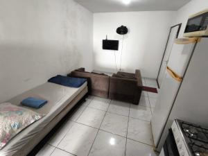 a small room with a bed and a couch at Ed Falcão quadra 2 lote 7 AP 402 in Riacho Fundo