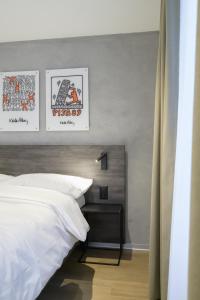Un pat sau paturi într-o cameră la Hôtel Arnold self check-in