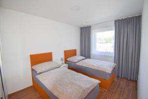 two beds in a room with a window at Chata U Bezedné in Velký Osek