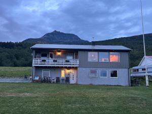 a house with a balcony and a mountain in the background at Aurora apartment Nygård in Sletta