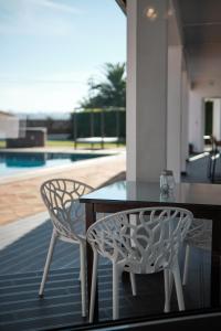 a table and chairs on a patio with a pool at A Casa Branca - with Pool & Jacuzzi in Santa Comba Dão