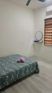 メ ルシンにあるRasa Sayang Homestay Mersingのベッドルーム1室(ベッド1台、緑の掛け布団付)