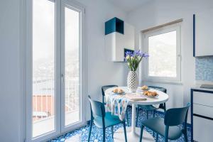 a kitchen with a table and chairs and a window at Blue Amalfi Luxury House - Vista mozzafiato in Amalfi