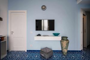 a room with a white wall with a mirror and a vase at Blue Amalfi Luxury House - Vista mozzafiato in Amalfi