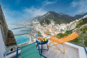 a balcony with a chair and a view of the ocean at Blue Amalfi Luxury House - Vista mozzafiato in Amalfi