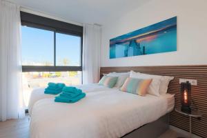 a bedroom with a bed with blue towels on it at Casa Madreselva by Rental Hero in Las Casicas +44 photos