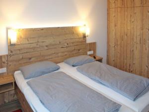 une chambre avec un lit avec une tête de lit en bois dans l'établissement Ferienhaus Nr 27, Kategorie Premium, Feriendorf Hochbergle, Allgäu, à Lechbruck am See